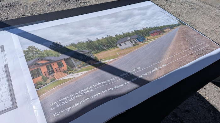 Une photo et des plans de maisons d'une future rue.