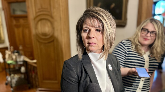 Lori Clark répond aux questions des journalistes à l'Assemblée législative. 