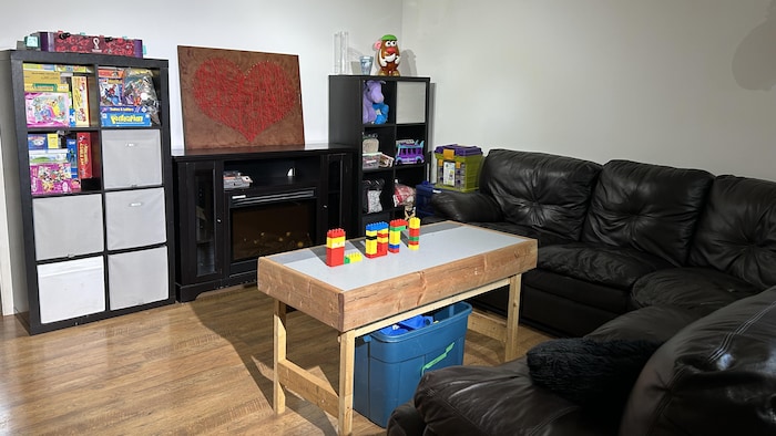 Un salon avec des jouets pour enfant. Sur la table basse, des blocs Lego forment le mot LORI. 