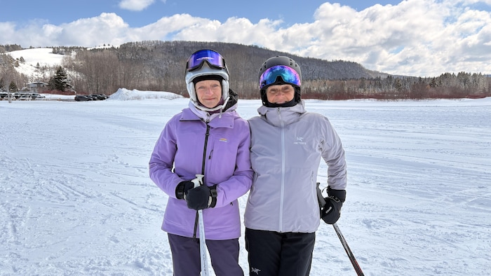 Deux femmes en habit de ski posent ensemble.