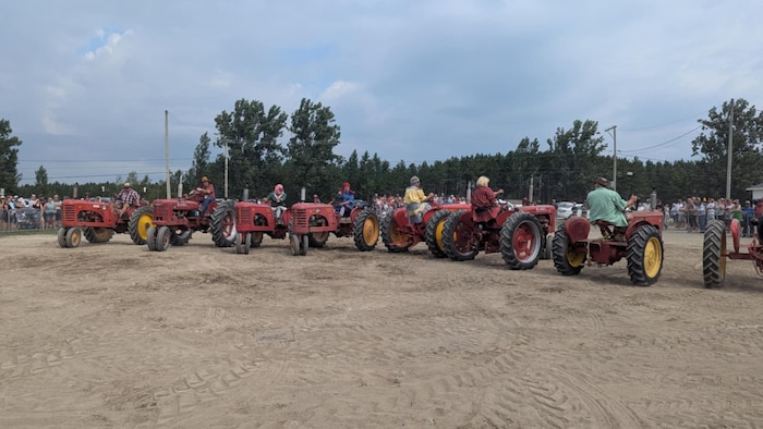 Des tracteurs sont sur une piste de sable