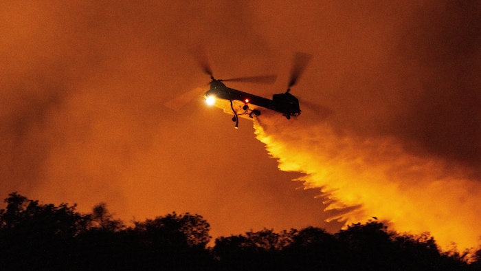 Un hélicoptère largue de l'eau sur l'incendie de Palisades dans le canyon de Mandeville le samedi 11 janvier 2025, à Los Angeles. 