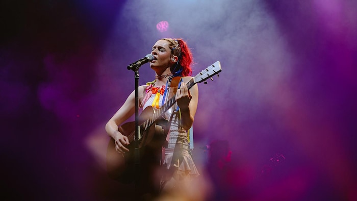 Lou-Adriane Cassidy chante en jouant de la guitare.