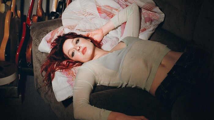 La jeune femme est allongée sur le divan dans une airs sensuelle.