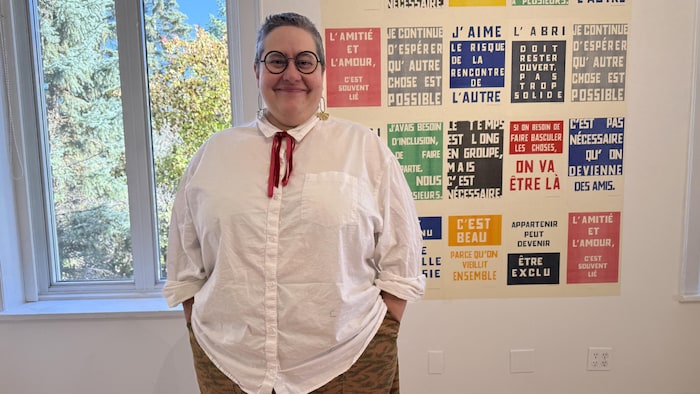 Lou-Anne Bourdeau se tient devant une oeuvre d'art.