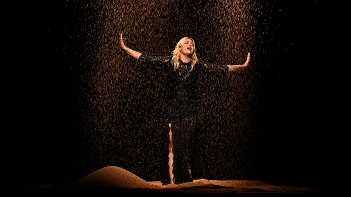 Une femme blonde chante sur scène.