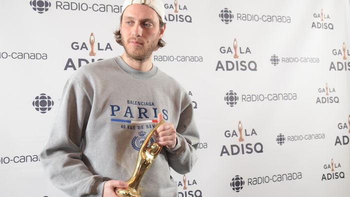 L'homme tient son trophée dans les mains.