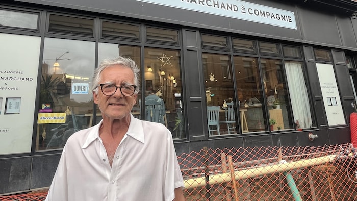 Louis Marchand pose devant son commerce.