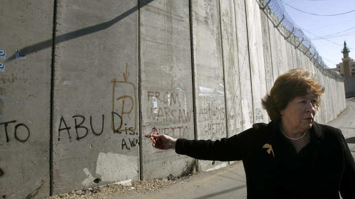 Une femme près d'un mur.