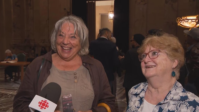 Deux femmes sourient devant un micro.