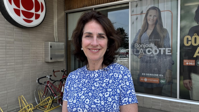 Louise Lévesque, souriante, devant les bureaux de Radio-Canada.