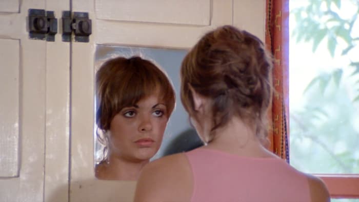 Louise Portale, alors âgée de 21 ans, se regarde dans un miroir. Elle est de dos.