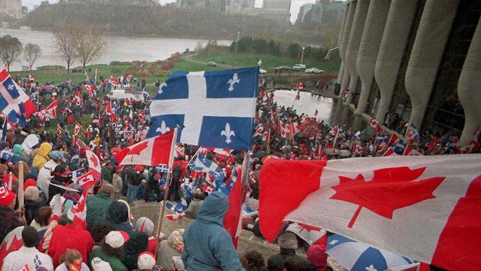 تجمع للمطالبين ببقاء كيبيك ضمن الاتحادية الكندية أمام متحف الحضارات في مدينة هول الكيبيكية خلال الحملة التي سبقت الاستفتاء العام في كيبيك حول الاستقلال الذي جرى في 30 تشرين الأول (أكتوبر) 1995. يحمل  المشاركون في التجمع أعلاماً كندية وكيبيكية.