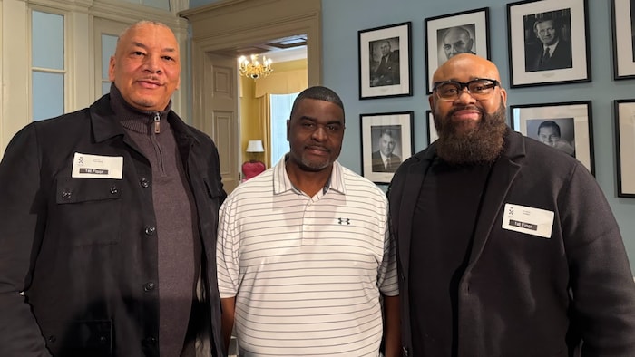 Trois membres de Love Nova Scotia souriant à Province House.