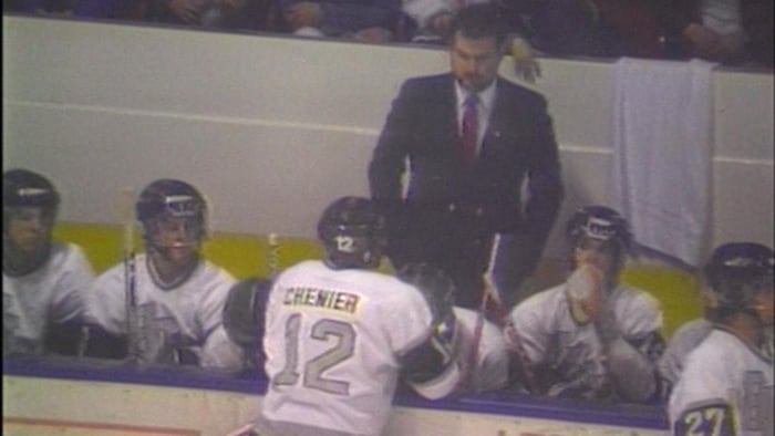 Un joueur de hockey parle à son entraîneur. 