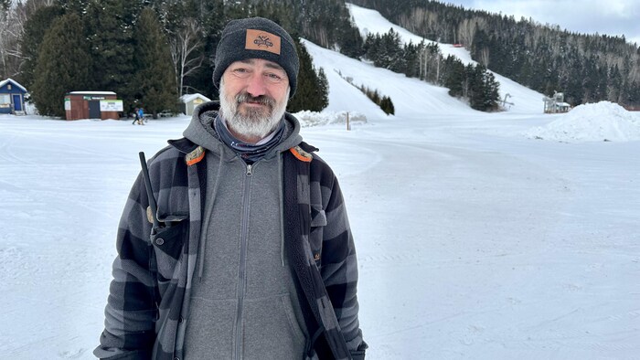 Luc Gagnon en habit d'hiver devant des pistes du Mont-Castor.
