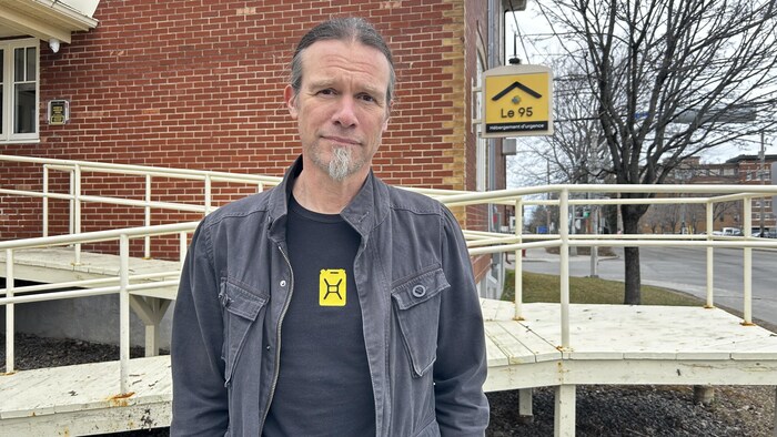 Portrait de Luc Jobin devant l'entrée principale du centre d'hébergement pour personnes en situation d'itinérance de Rimouski. 