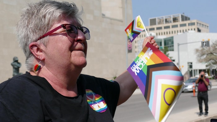 Lucette Lipkovsky a un drapeau arc-en-ciel dans les mains.