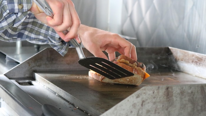 Un sandwich grillé au fromage sur la plaque de cuisson.