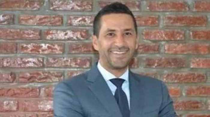 Luciano Frattolin, souriant, les bras croisés.