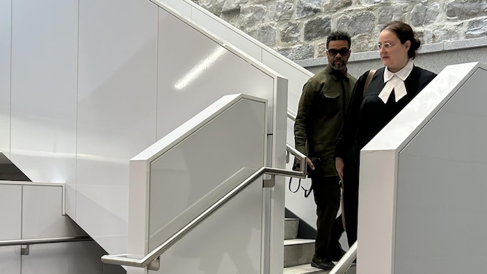 Un homme et une avocate dans les escaliers.