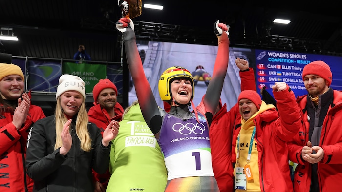Elle lève les bras au ciel pour célébrer son titre olympique.