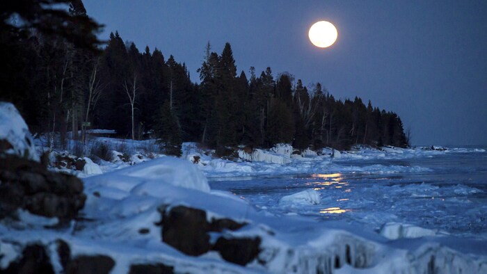 La lune brille sur le lac Supérieur gelé.