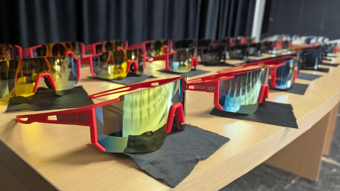 Des lunettes de soleil à la mode sont présentées sur une tables avec leur chiffon.