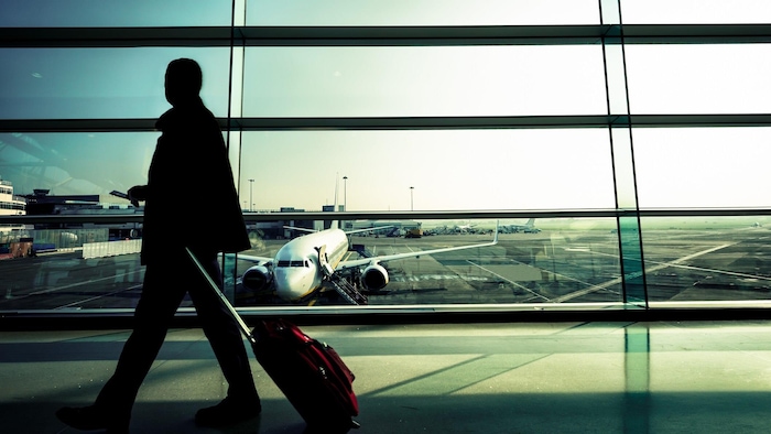 Une personne se promène avec une valise à l'aéroport.