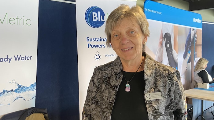 Lydia Renton devant une pancatre de son entreprise.