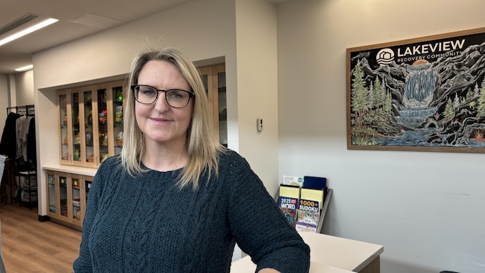 Une femme prend la pose devant un bureau. 