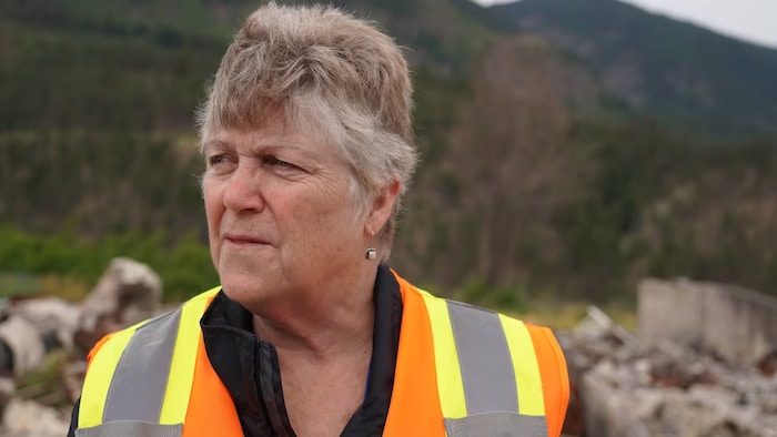 Portrait de Denise O'Connor, avec une veste orange et jaune.