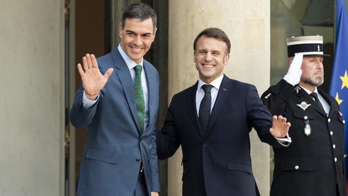Le premier ministre espagnol Pedro Sanchez et le président français Emmanuel Macron saluent les journalistes.