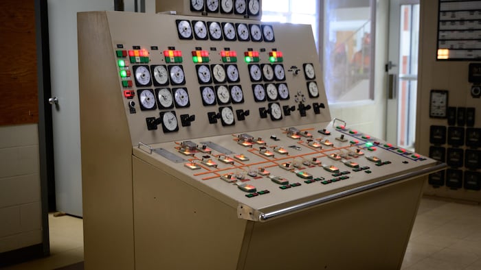 Un bureau beige avec plusieurs boutons illuminés.