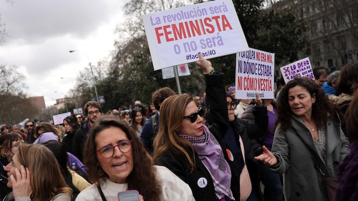Une femme brandit une pancarte qui porte la mention « La révolution sera féministe ou ne sera pas » en espagnol.