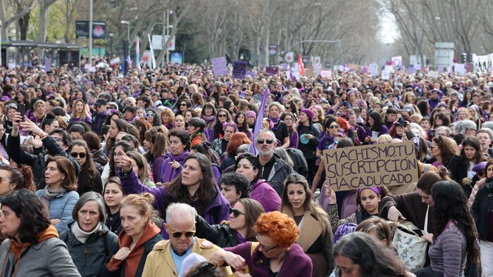 Une jeune femme brandit une pancarte qui porte la mention « Le machisme, c'est fini » en espagnol lors d'une manifestation organisée à l'occasion de la Journée internationale des femmes à Madrid.