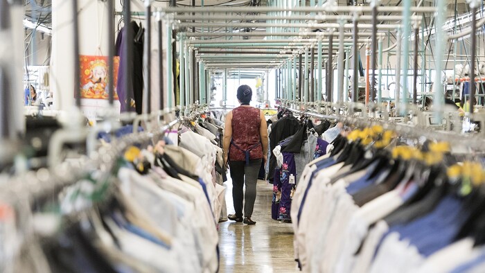 عاملة تسير داخل مصنع للألبسة في مونتريال.