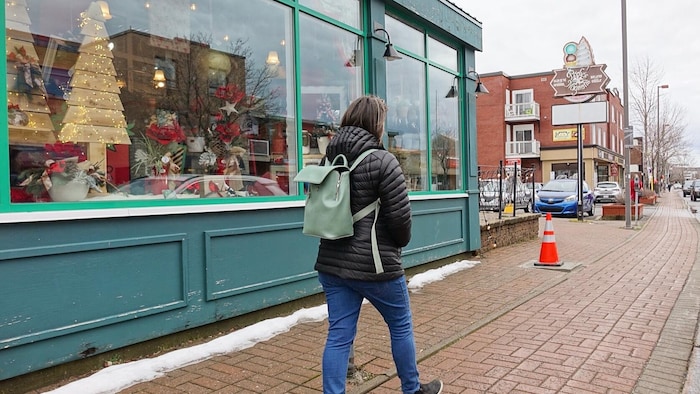 Une personne marche devant des commerces de la rue Saint-Germain, à Rimouski.