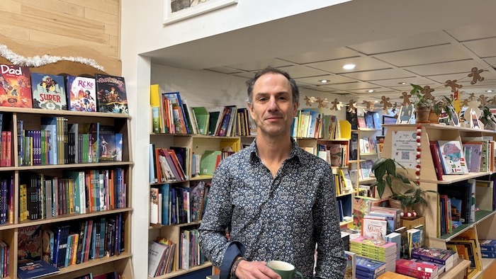Un homme devant des livres.