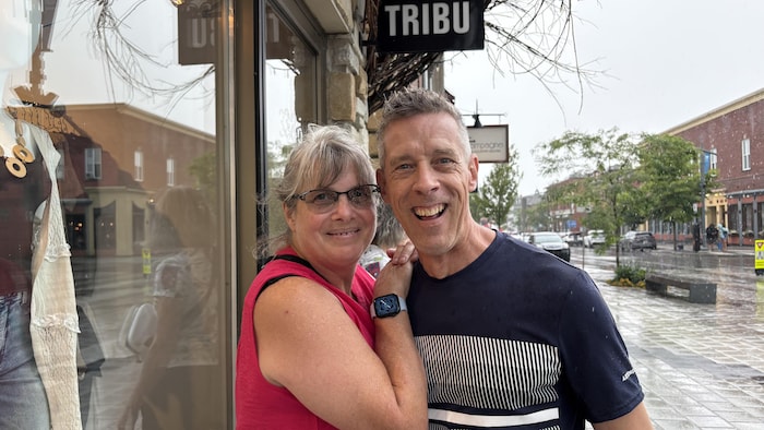 Un homme et une femme sourient à la caméra, au centre-ville de Magog.