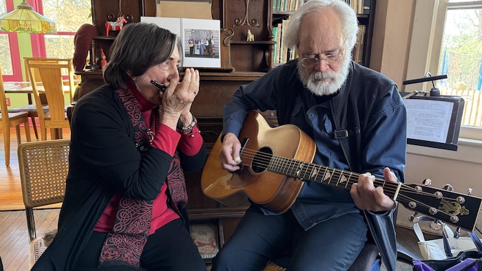 Un homme à la guitare et une femme à l'harmonica.