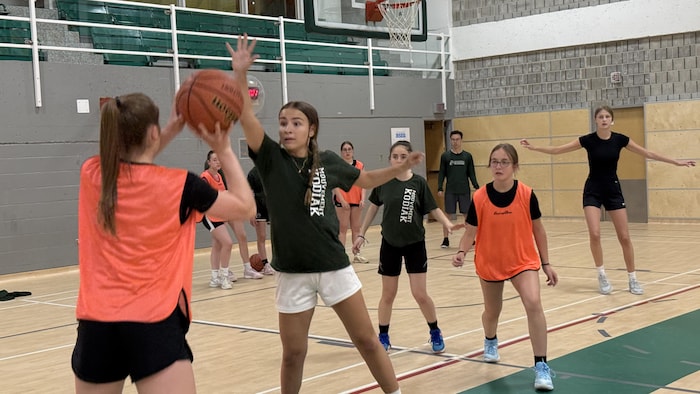 Des jeunes filles jouent au basketball.