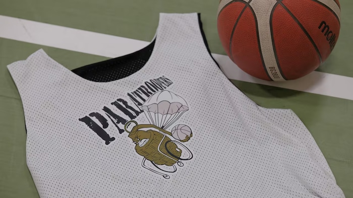 Le maillot de l'équipe de basketball en fauteuil roulant, les Paratroopers de Regina, et une balle de basketball.