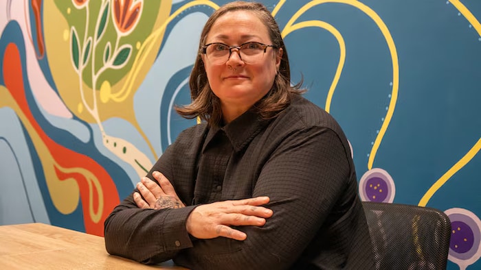 Une personne assise en lunettes.