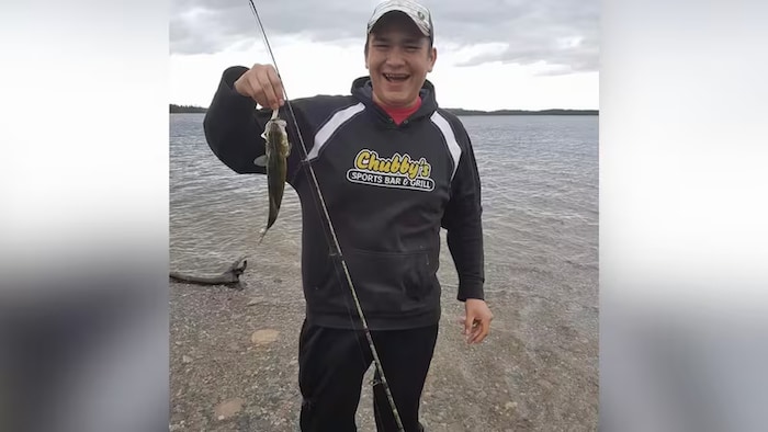 Un homme tenant un poisson.