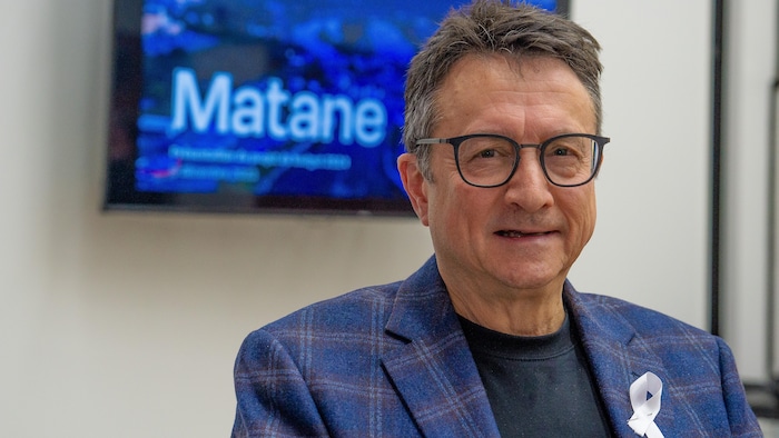 Eddy Métivier devant le logo de la Ville de Matane.