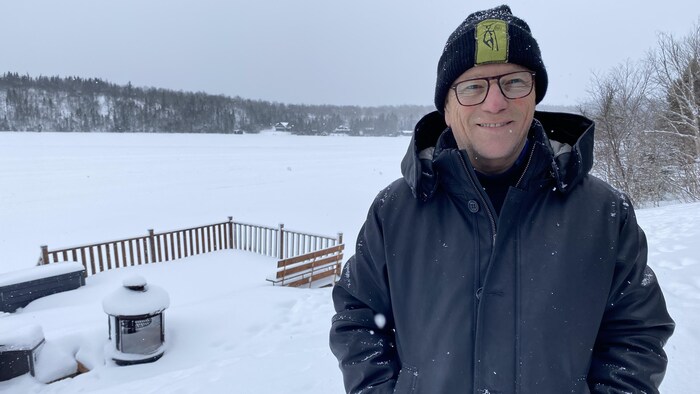 Un homme pose devant un lac gelé.