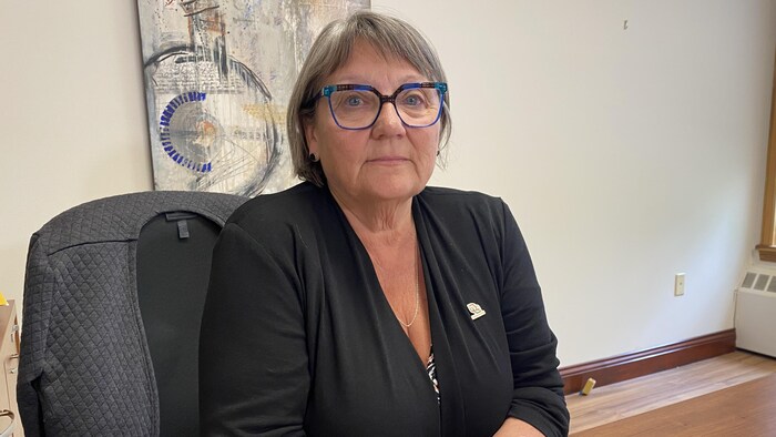 Sylvie Beauregard regarde la caméra. Elle est assise à son bureau.