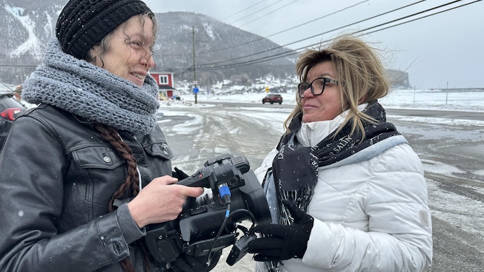 La mairesse de Mont-Louis est à l'extérieur sous un temps neigeux, elle parle avec une femme tenant une caméra.