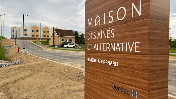 Affiche qui présente la maison en avant du bâtiment.